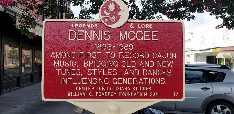 Historical marker in a downtown street celebrating the contributions of Dennis McGee to traditional Cajun music.